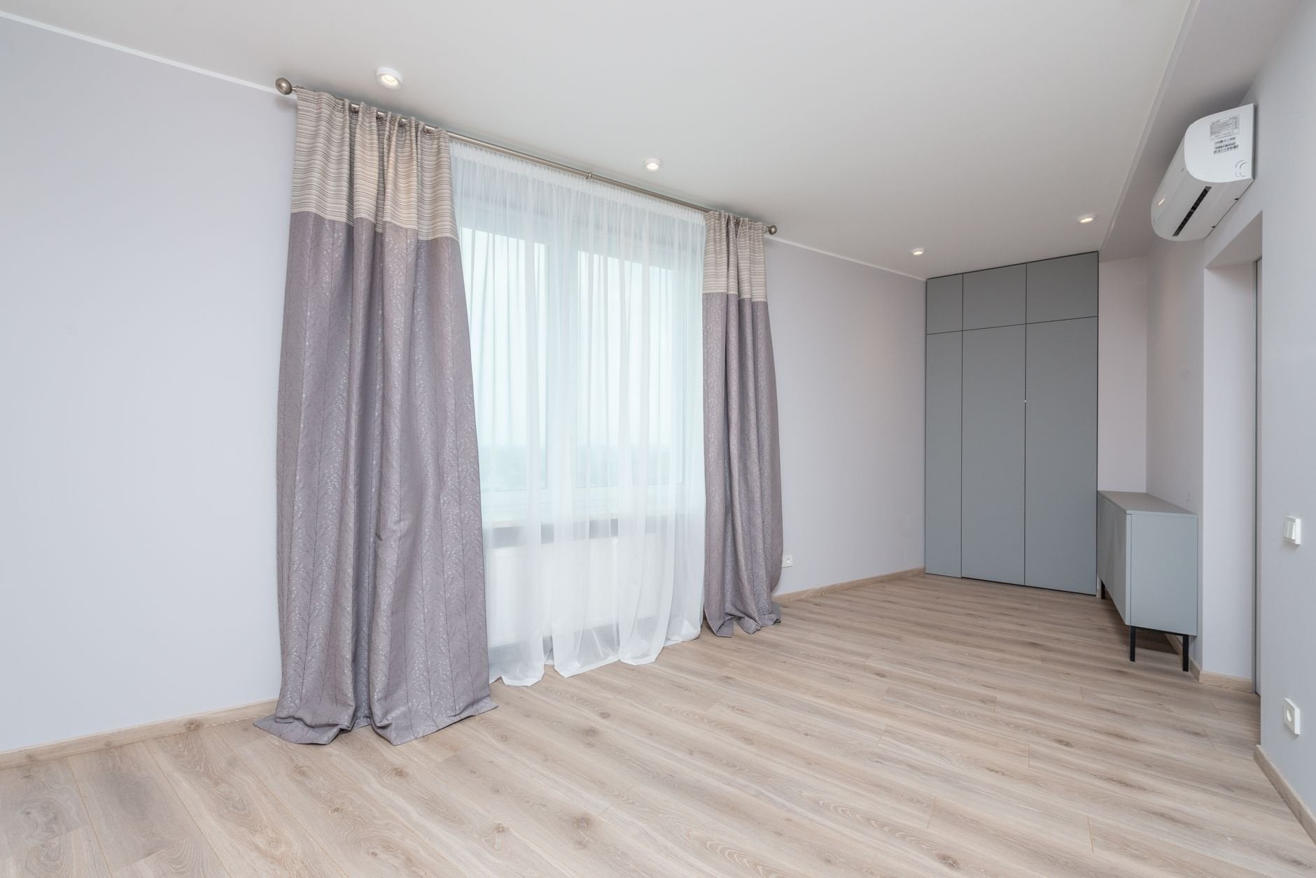 Modern room interior with cabinet and closet on floor under air conditioning and lamps in light house